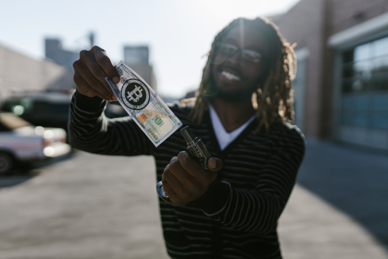 Smiling man holding a Bitcoin-themed dollar bill with focus on financial innovation.